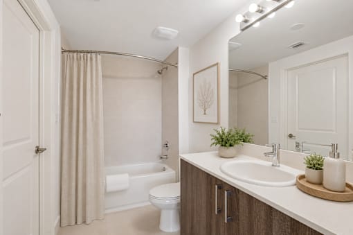 A bathroom with a toilet, sink, and shower.