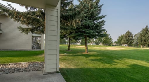 Coeur d'Alene, ID, Apartments - Rockwood Lodge - Private Terrace With View Of Large Open Grass Space And Trees.