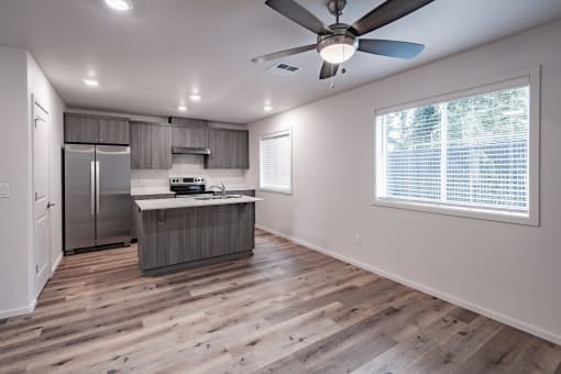 a kitchen with a large window and a ceiling fan