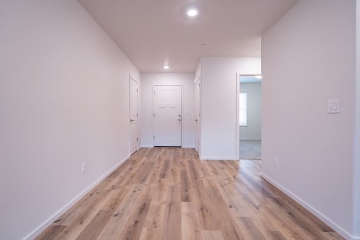 a bedroom with hardwood floors and white walls