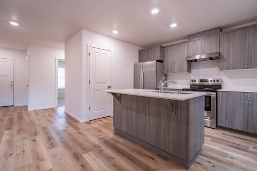 a kitchen with white walls and a wooden floor