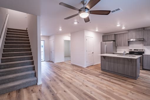 an open floor plan with a staircase leading up to the kitchen and living room