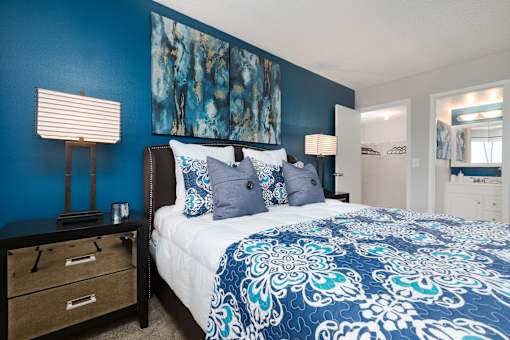 A bedroom with a bed, nightstand, and lamp.