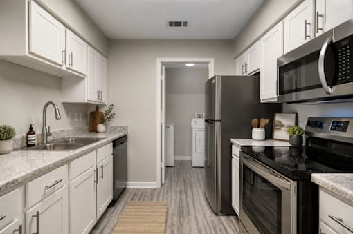 Rutland Place Apartment Homes in Macon, Georgia with A modern kitchen with white cabinets and stainless steel appliances.