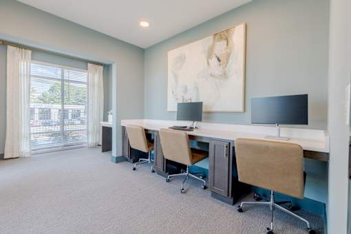Resident business center with comfortable workstations at Sage 5430 apartments near Peachtree Corners, Georgia.