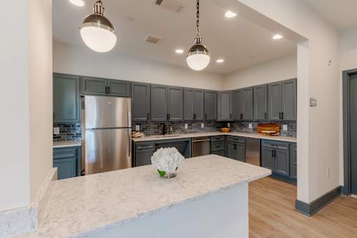 Resident clubhouse kitchen with modern cabinetry and gathering space at Sage 5430 apartments in Norcross, GA.
