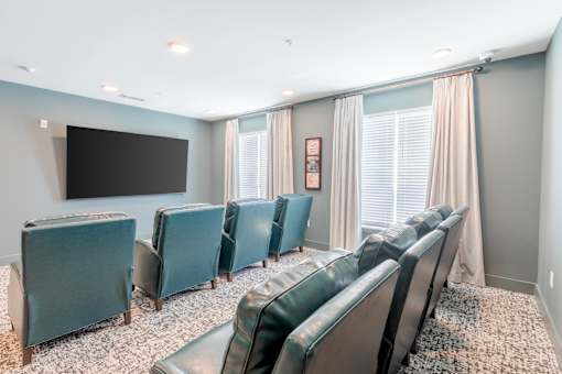 Community theater room with reclining chairs for resident movie nights at Sage 5430 near Buford Highway.