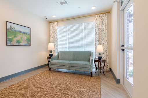 Comfortable community sitting area with large windows inside Sage 5430 55+ apartments in Gwinnett County.