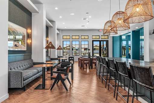 A modern dining area with wooden floors and black chairs.
