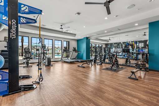 A gym with a variety of equipment including treadmills, weights, and exercise machines.