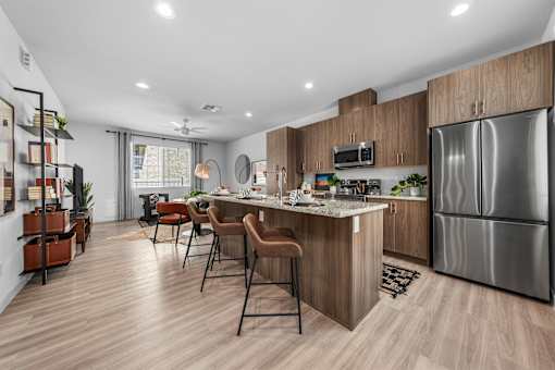 A modern kitchen with a bar area and a refrigerator.