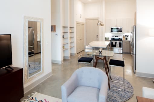 A modern kitchen with a blue chair in the middle of the room.