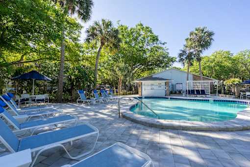 a pool with lounge chairs and a building in the background