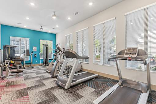 A gym with treadmills and other exercise equipment.