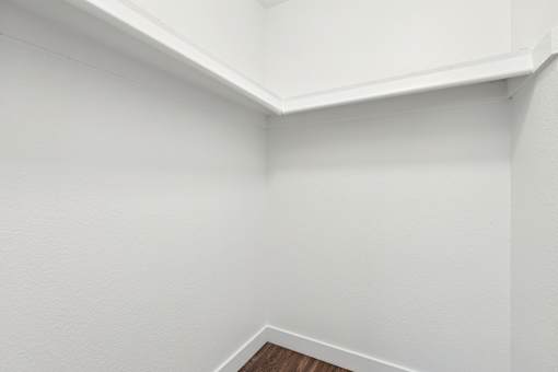 A white wall with a corner of a room.