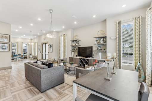 A well-lit, spacious living room with a grey sofa and a grey coffee table.