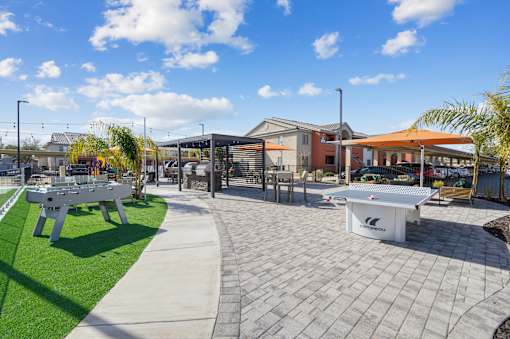 A white table tennis table is in the middle of a paved area.