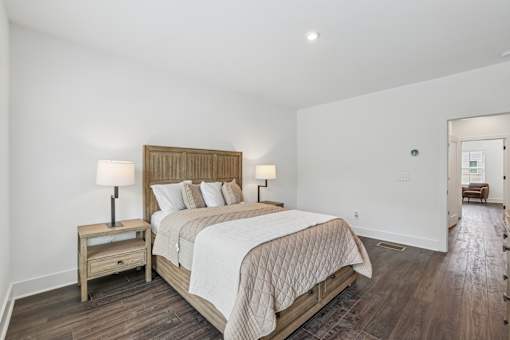 A bedroom with a bed, nightstand, and lamp.