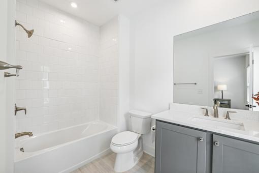 A white bathroom with a toilet, sink, and bathtub.