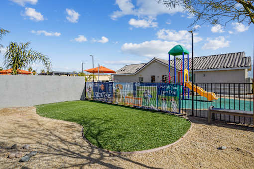 A playground with a green slide and a mural on the wall.
