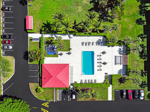 A red building with a pool in front of it.