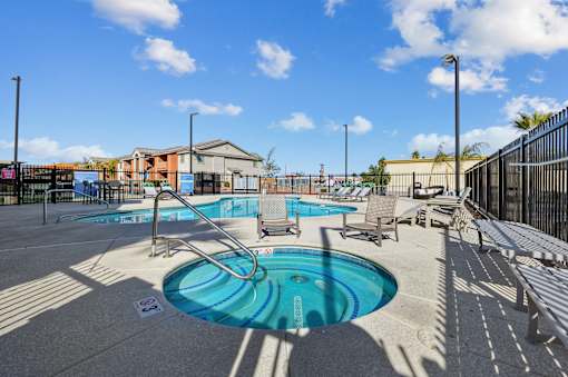 A pool with a slide and sun loungers.