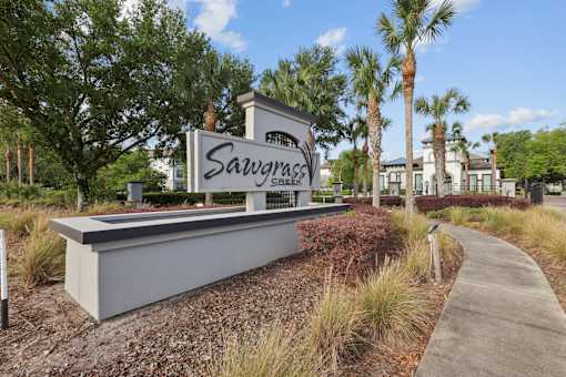 A sign that says SavvyGlass in front of some trees.