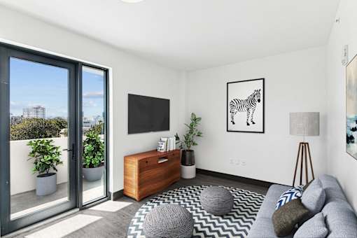 A living room with a grey sofa, a wooden side table, and a zebra print rug.