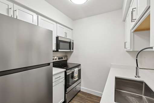 A modern kitchen with stainless steel appliances and white cabinets.
