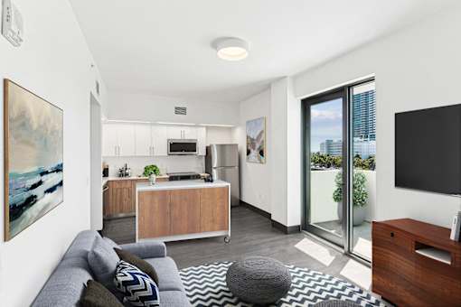 A modern living room with a grey sofa and a grey pouf.