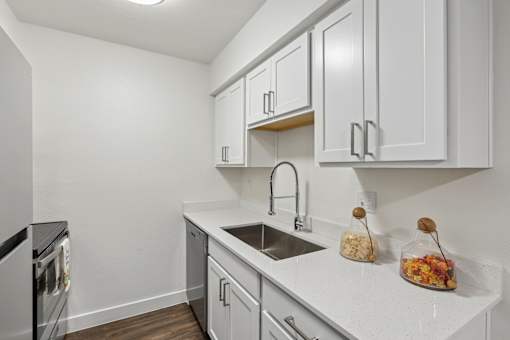 A kitchen with white cabinets and a black oven.