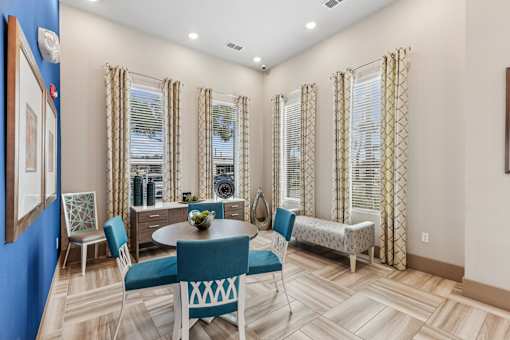 A dining room with a blue table and chairs.