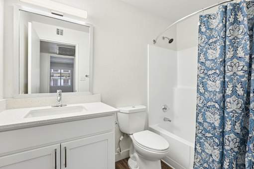 A white bathroom with a sink, toilet, and bathtub.