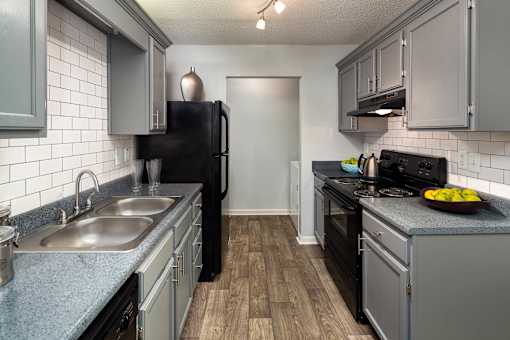 Kitchen with black appliances in Stockbridge GA apartment at Southwinds Point near Eagles Landing