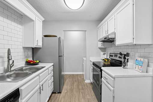 Modern kitchen with white cabinetry and stainless steel appliances at Southwinds Point Apartments in Stockbridge, Georgia.