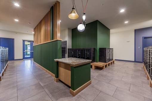 a large room with a table and benches in front of a green wall