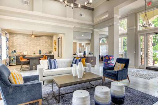 A living room with a white couch and a blue chair.