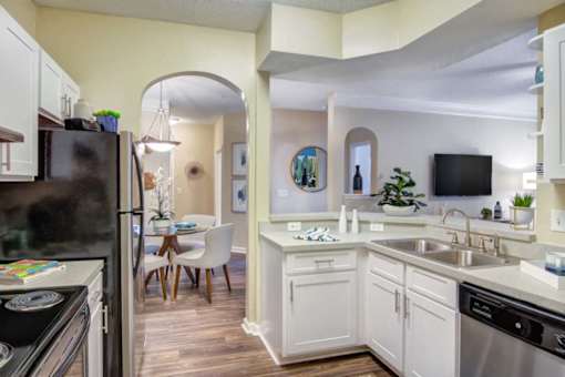 A kitchen with a black fridge and a white counter.