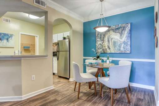 A kitchen with a table and chairs.