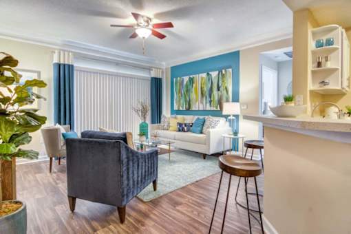 A living room with a blue chair and a white couch.