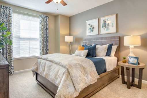 A bedroom with a large bed and a ceiling fan.