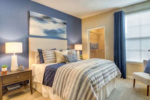 A bedroom with a large bed and a painting on the wall.