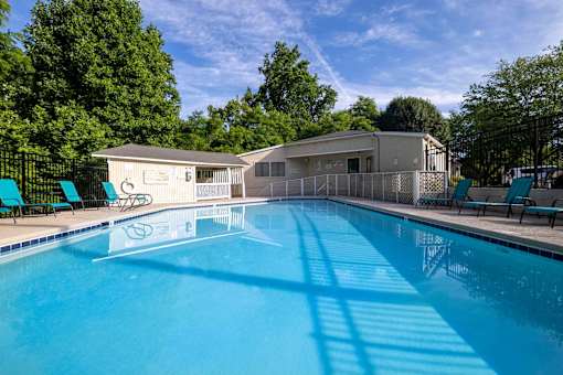 Resort-style swimming pool and clubhouse at Sugar Creek Apartments in Winston-Salem, NC with lounge seating and landscaped surroundings