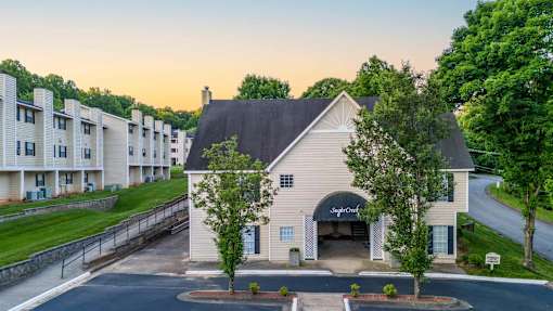 Leasing Office entrance at Sugar Creek Apartments with landscaped grounds and nearby apartment homes in Winston-Salem