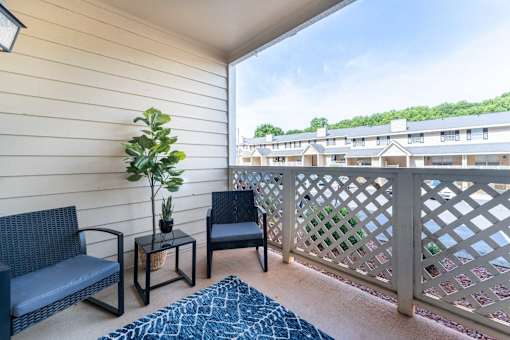 Apartment balcony in Winston-Salem North Carolina at Sugar Creek Apartments with patio seating and residential community view