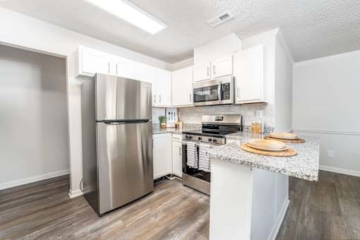Spacious upgraded apartment kitchen with stainless appliances and granite countertops at Sugar Creek Apartments Winston Salem
