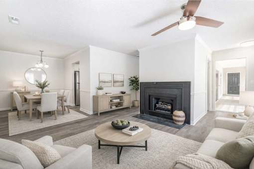 Modern apartment living room with fireplace dining area and open floor plan at Sugar Creek Apartments Winston Salem