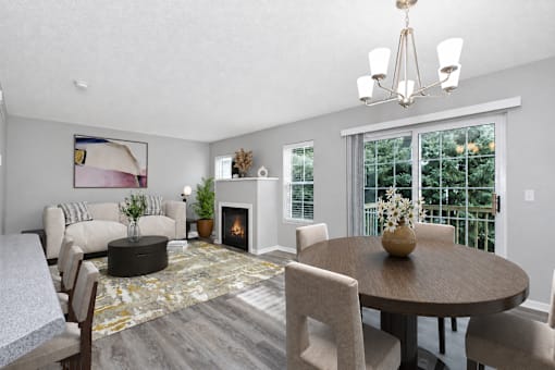Virtually staged living and dining room at Summit Townhomes in Burnsville, MN, with a fireplace and sliding patio doors.