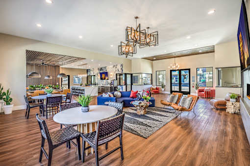 Luxurious and spacious apartment lounge at Summit on Boulder Apartments with stylish seating, modern chandeliers, and vibrant decor, offering a welcoming ambiance with elegant wooden flooring and abundant natural light.