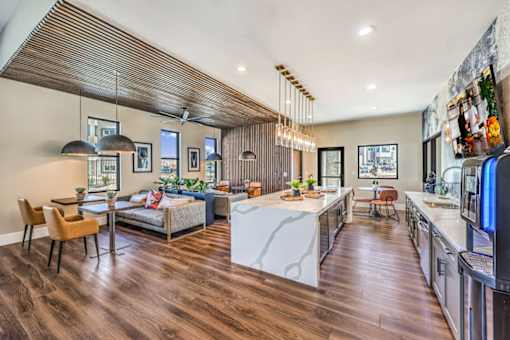 Luxurious open-plan clubroom at Summit on Boulder Apartments featuring stylish kitchen island, elegant dining area, and cozy seating with modern decor.